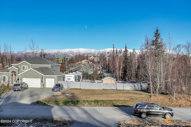 exterior space featuring a mountain view, a front yard, and a garage