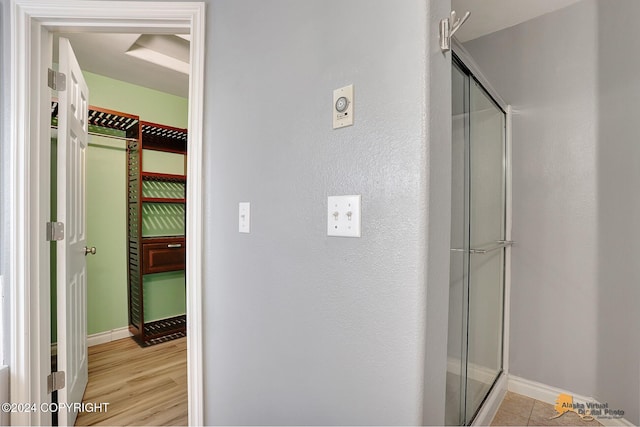 bathroom with an enclosed shower and hardwood / wood-style floors