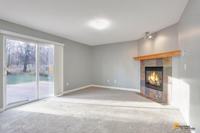 unfurnished living room featuring carpet flooring and a fireplace