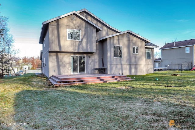 rear view of house with a deck and a yard