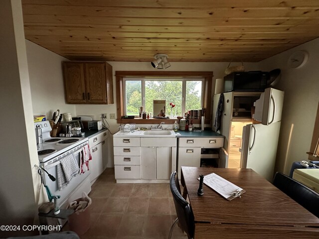 kitchen featuring wooden ceiling, light tile patterned flooring, a sink, and white range with electric cooktop
