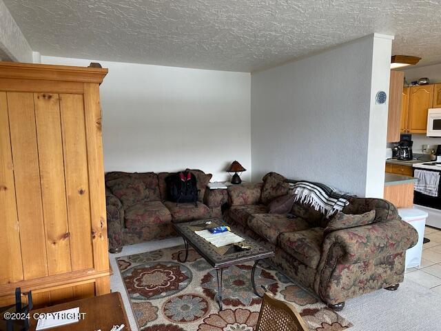 tiled living room featuring a textured ceiling