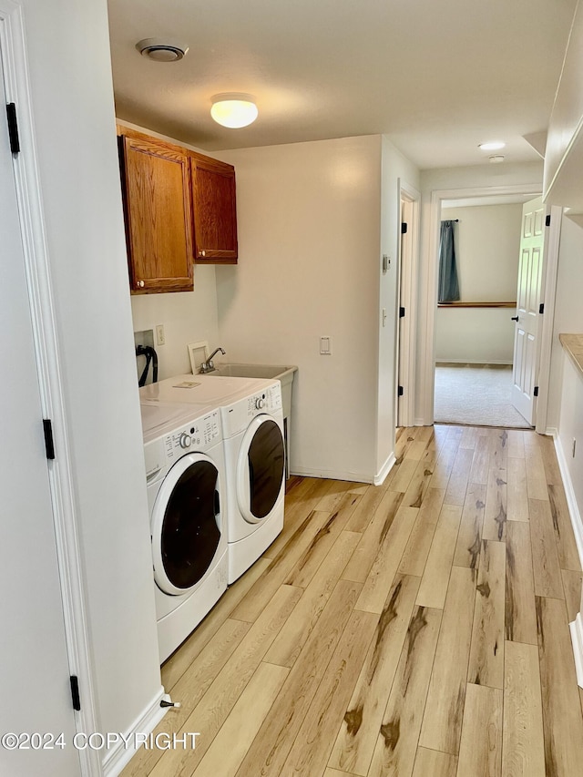 41385 Ptarmigan Heights Dr, Homer, AK 99603 - laundry area featuring cabinet space, light wood-style flooring, washing machine and dryer, and baseboards