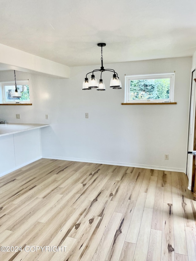 41385 Ptarmigan Heights Dr, Homer, AK 99603 - unfurnished dining area featuring wood finished floors, a chandelier, and baseboards
