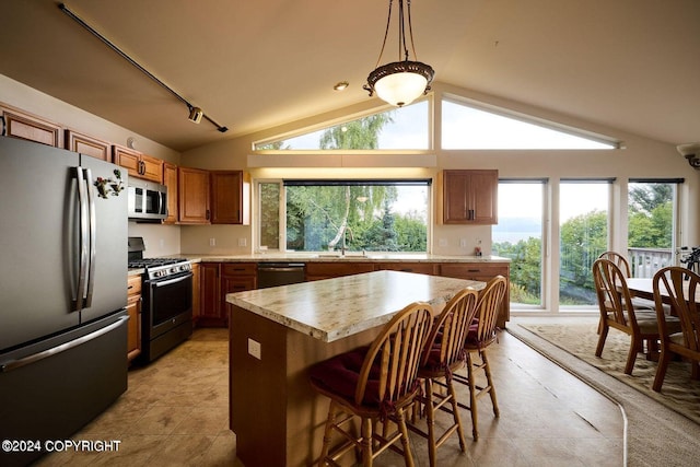 41385 Ptarmigan Heights Dr, Homer, AK 99603 - kitchen featuring appliances with stainless steel finishes, light countertops, brown cabinets, lofted ceiling, and light tile patterned floors