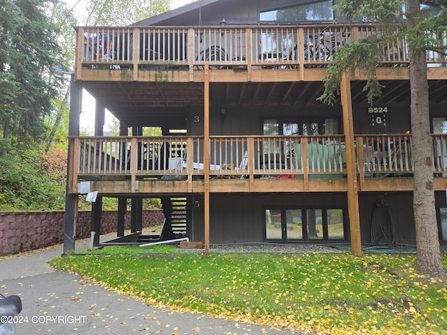 back of house with a lawn and a deck