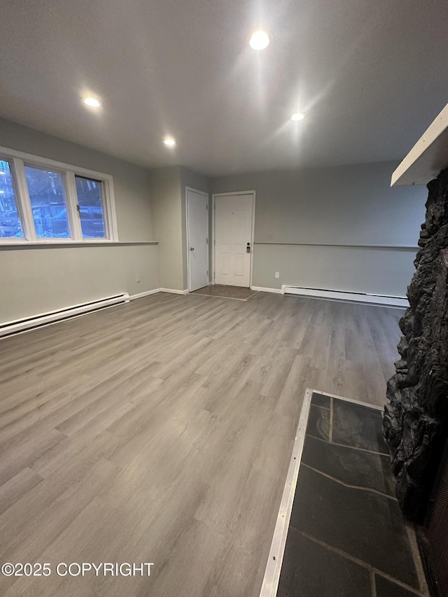 basement featuring baseboard heating and hardwood / wood-style floors