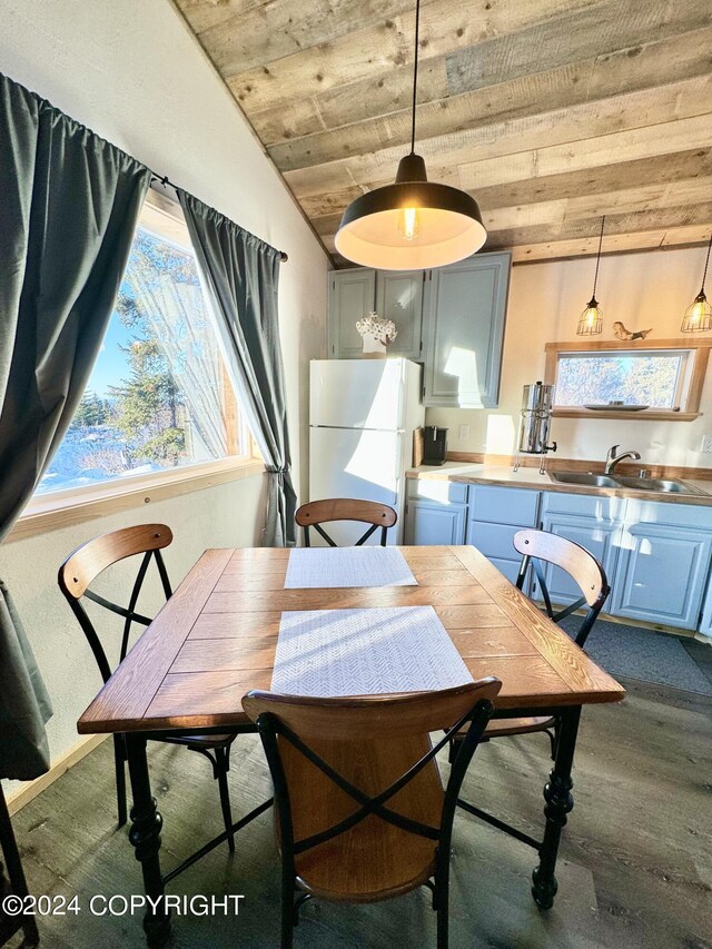 dining area with dark hardwood / wood-style flooring, vaulted ceiling, wooden ceiling, and sink