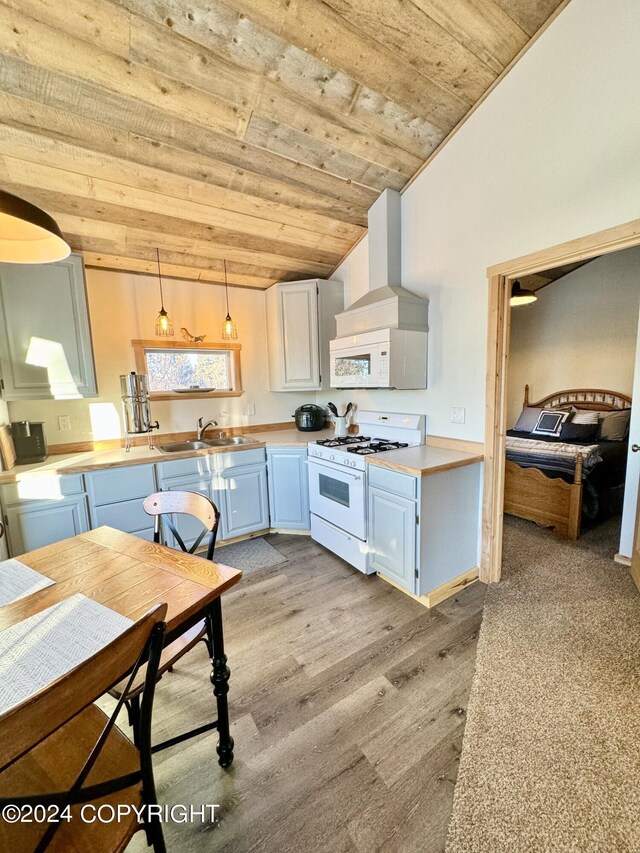 kitchen with ventilation hood, lofted ceiling, light hardwood / wood-style flooring, decorative light fixtures, and white range with gas cooktop