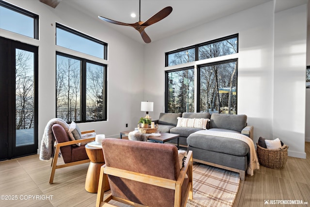 tiled living room featuring a high ceiling and ceiling fan