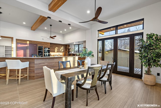 dining area with a towering ceiling, ceiling fan, french doors, and beamed ceiling