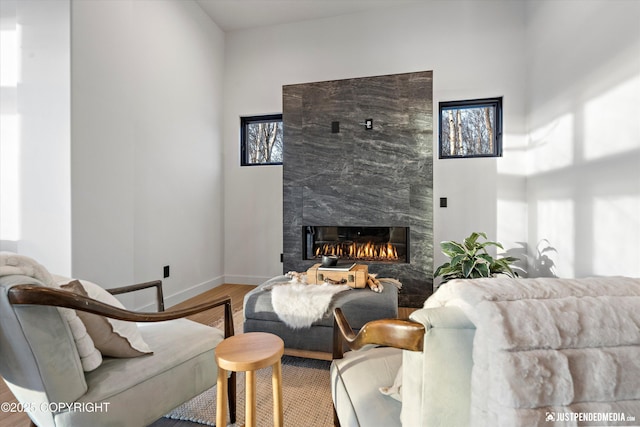 living room featuring a high end fireplace and hardwood / wood-style flooring