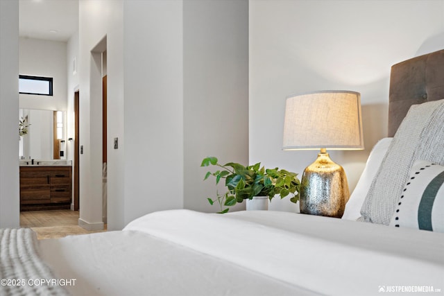 bedroom featuring ensuite bathroom and light hardwood / wood-style floors