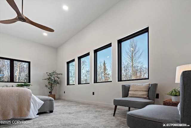 living area with light carpet, high vaulted ceiling, and ceiling fan