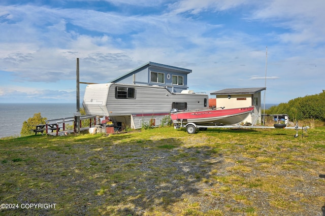 rear view of house featuring a yard and a water view