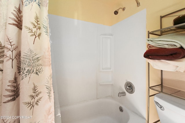 bathroom featuring shower / bath combo with shower curtain and toilet