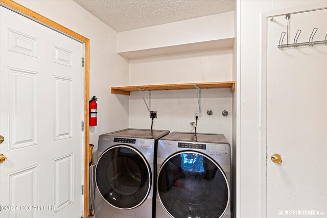 washroom with a textured ceiling and washing machine and clothes dryer