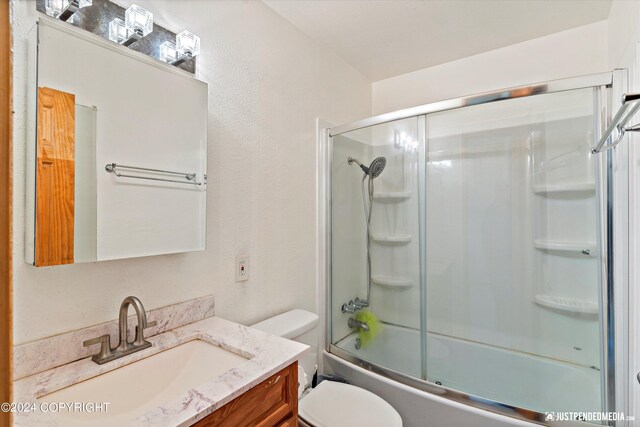 full bathroom with shower / bath combination with glass door, vanity, and toilet