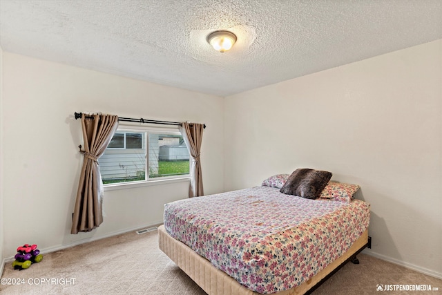 carpeted bedroom featuring a textured ceiling