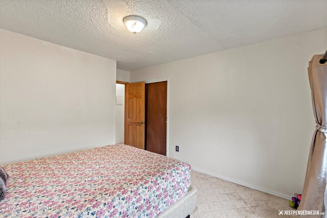 carpeted bedroom featuring a textured ceiling