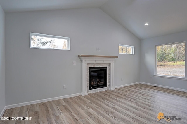 unfurnished living room with light hardwood / wood-style floors, high vaulted ceiling, and a wealth of natural light