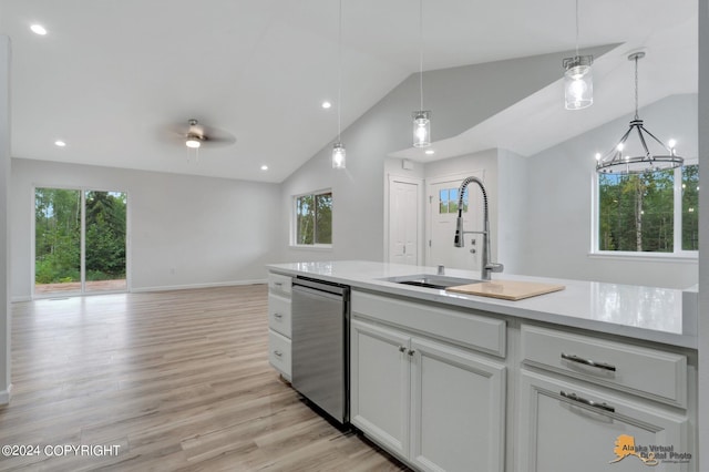 kitchen with a wealth of natural light, dishwasher, light hardwood / wood-style floors, and vaulted ceiling