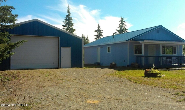 view of side of property featuring an outbuilding, a garage, and a porch