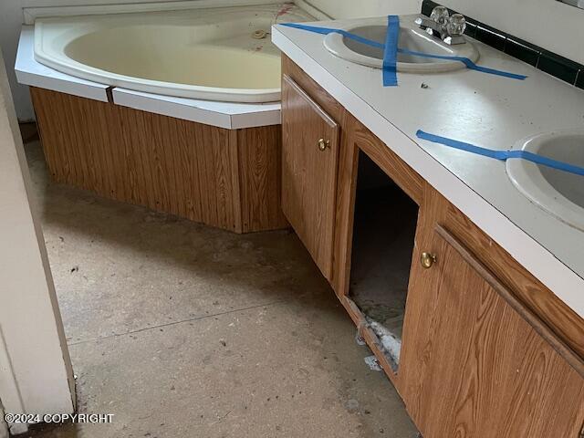 bathroom featuring vanity and a tub to relax in