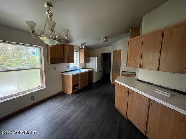 kitchen featuring an inviting chandelier, white refrigerator, and dark hardwood / wood-style flooring