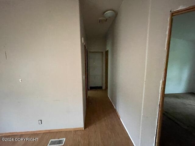 corridor with hardwood / wood-style flooring