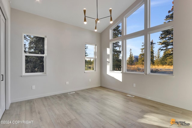 interior space featuring light hardwood / wood-style floors, a chandelier, and high vaulted ceiling