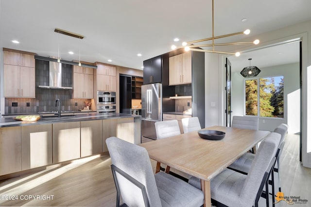 dining room featuring sink, light hardwood / wood-style flooring, and a notable chandelier