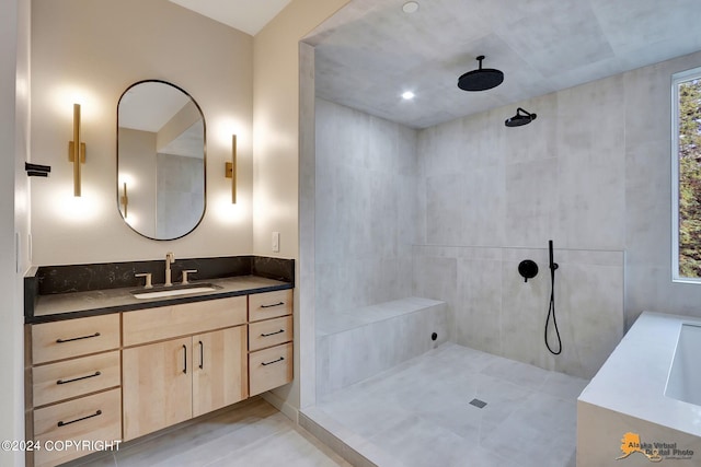 bathroom with a tile shower, tile patterned flooring, and vanity