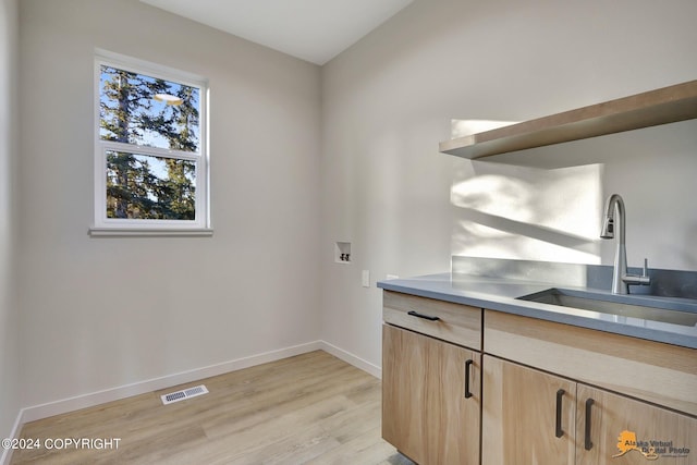 interior space with light brown cabinetry, light wood-type flooring, and sink