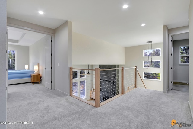 hallway with light colored carpet and plenty of natural light