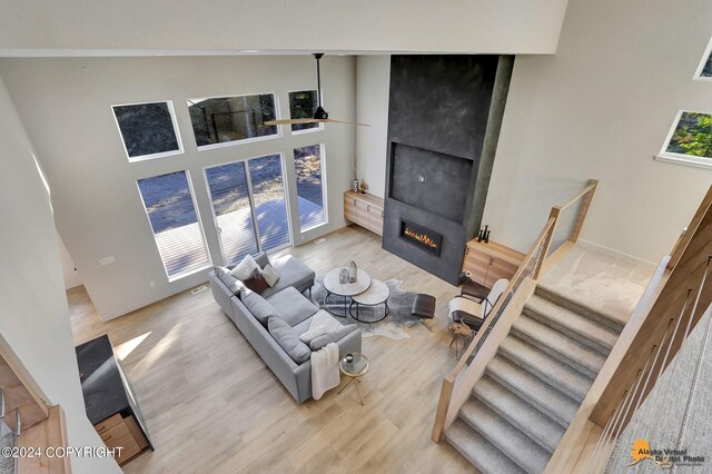 living room with a high ceiling, ceiling fan, and hardwood / wood-style flooring