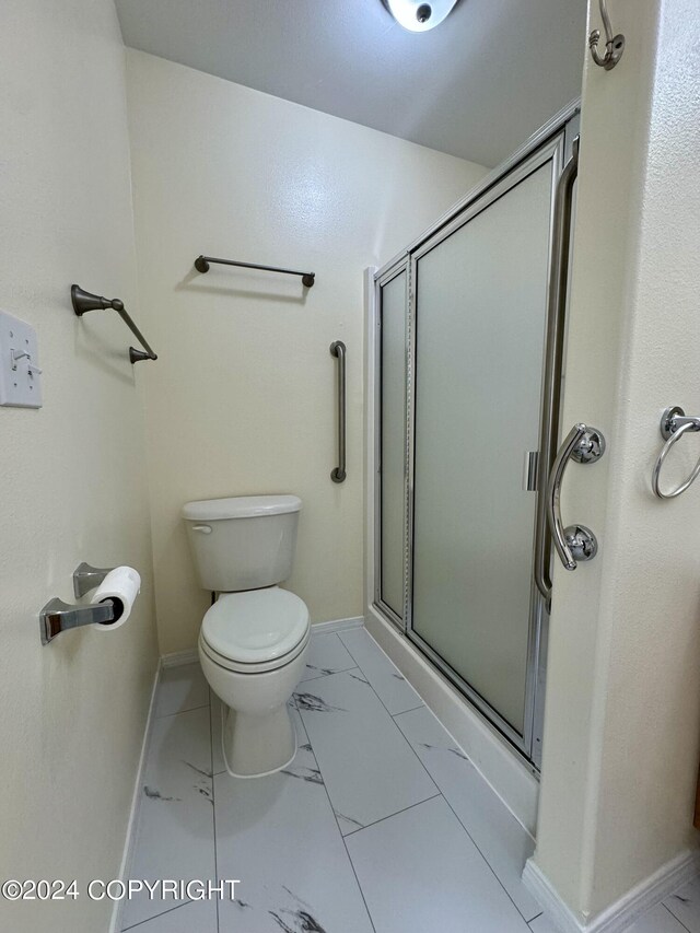 bathroom with an enclosed shower and toilet