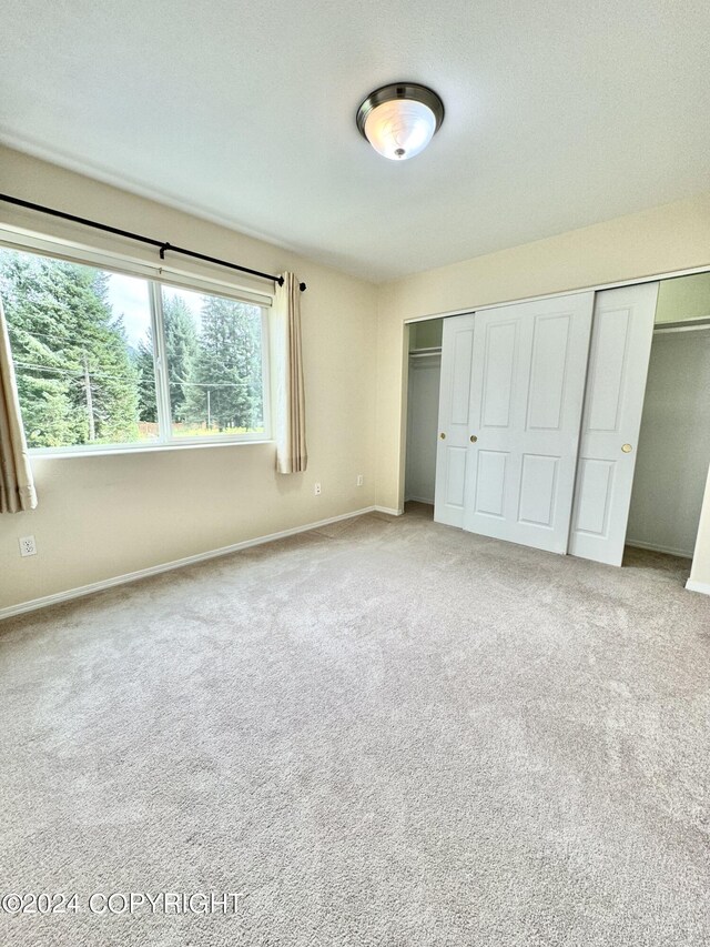 unfurnished bedroom with a closet and carpet flooring