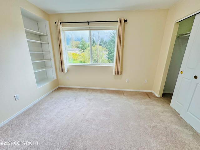 unfurnished bedroom featuring light carpet and a closet