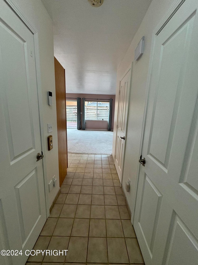 hall with light tile patterned floors