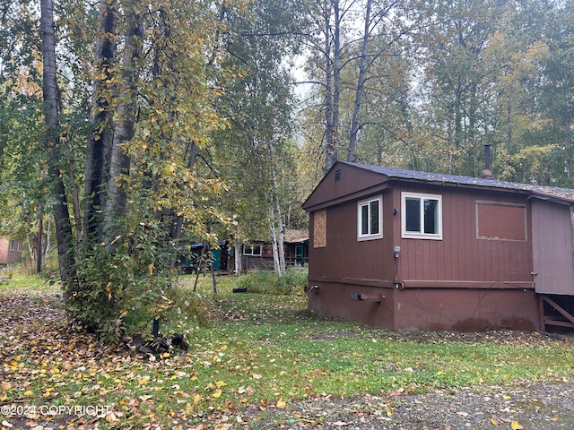 view of side of home with a yard