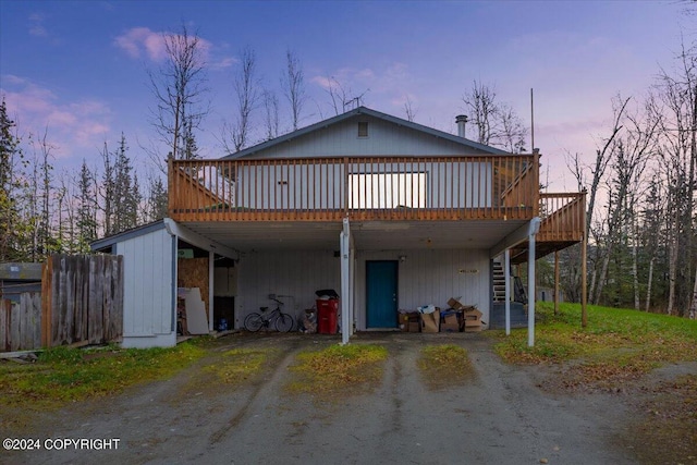 back house at dusk featuring a wooden deck