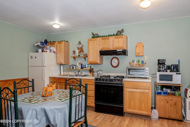 kitchen with light wood-type flooring, a textured ceiling, sink, white appliances, and light brown cabinets