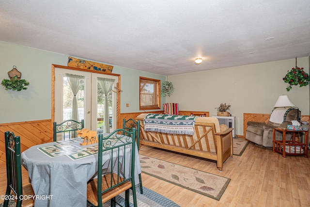 37325 Funny Moose Ln, Soldotna, AK 99669 - bedroom featuring access to outside, wainscoting, a textured ceiling, french doors, and light wood-style flooring