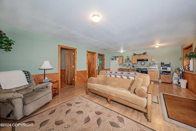 37325 Funny Moose Ln, Soldotna, AK 99669 - living room with a wainscoted wall, light wood-type flooring, wood walls, and a textured ceiling