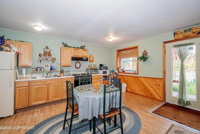37325 Funny Moose Ln, Soldotna, AK 99669 - kitchen featuring freestanding refrigerator, under cabinet range hood, light countertops, wainscoting, and range with gas cooktop