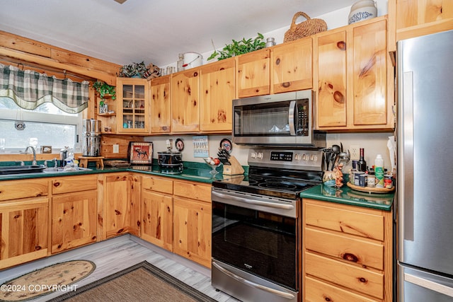 37325 Funny Moose Ln, Soldotna, AK 99669 - kitchen featuring stainless steel appliances, dark countertops, glass insert cabinets, and light wood-style floors