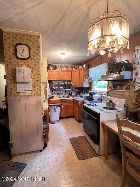 kitchen with a chandelier, a textured ceiling, white stove, range hood, and decorative light fixtures