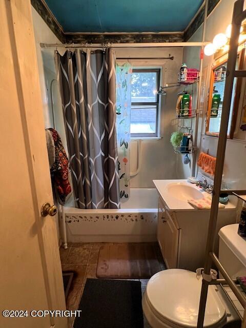 full bathroom featuring vanity, shower / bath combo with shower curtain, toilet, and tile patterned flooring