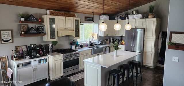 kitchen with a kitchen island, wood ceiling, a sink, high quality appliances, and a kitchen breakfast bar